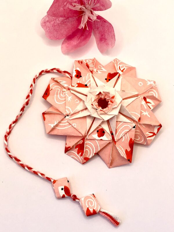 Marque page en origami , en forme de mandala et de couleur rose et rouge