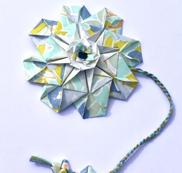 Marque page en origami en forme de mandala de couleur bleu ciel et vert anis
