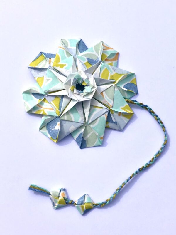 Marque page en origami en forme de mandala de couleur bleu ciel et vert anis
