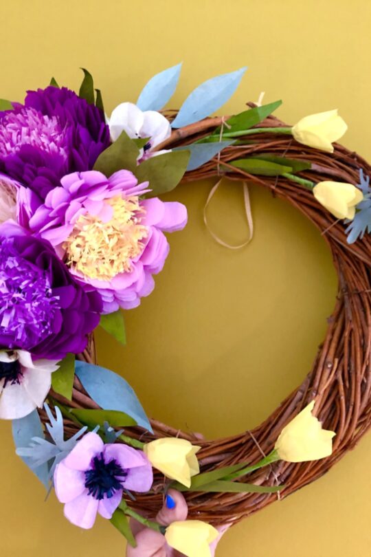 Couronne de fleurs de papier de soie violette et jaune.
